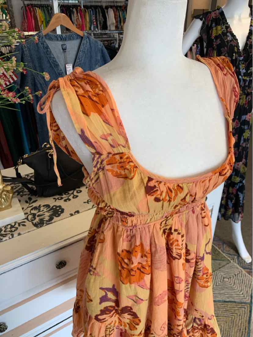 Peach-orange floral dress with puffed shoulder straps and fitted bodice on mannequin.