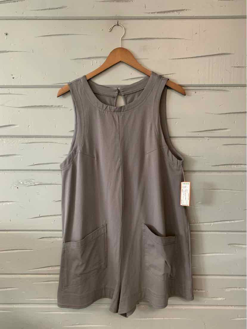 Sleeveless medium gray tunic dress with round neckline, front patch pockets, and loose fit on wooden hanger.