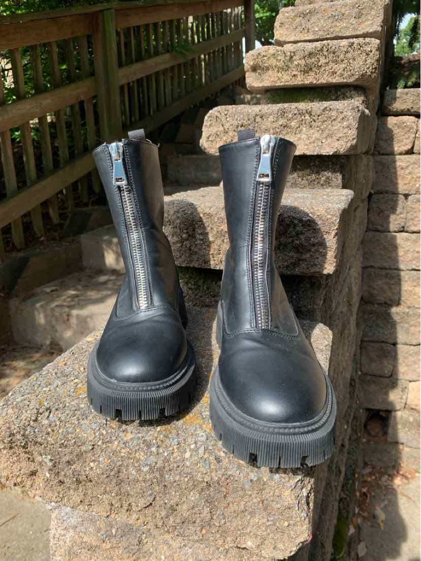 Black leather ankle boots with chunky lug soles and front zippers, size 7.5.