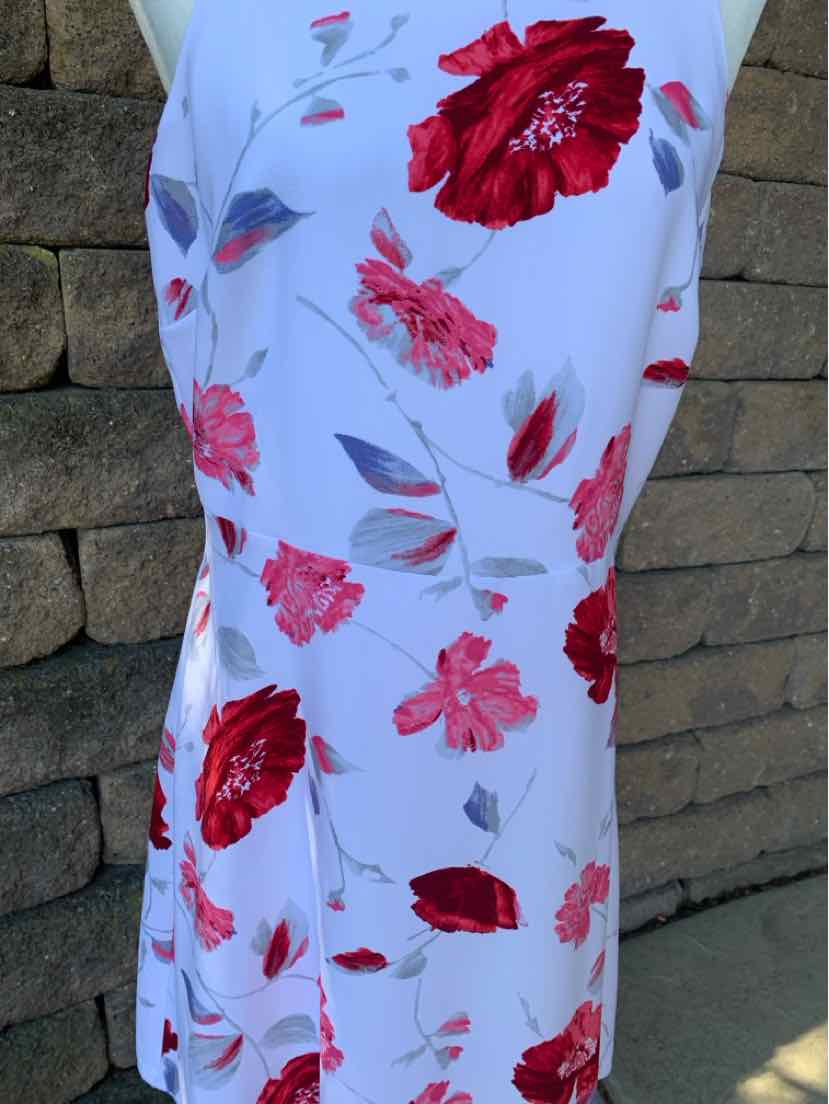 White sleeveless dress with large red and pink floral print and light gray leaves.