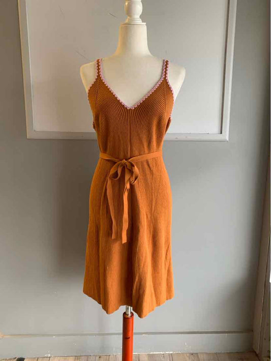 Tan knit sleeveless dress with V-neck and front tie belt on mannequin.