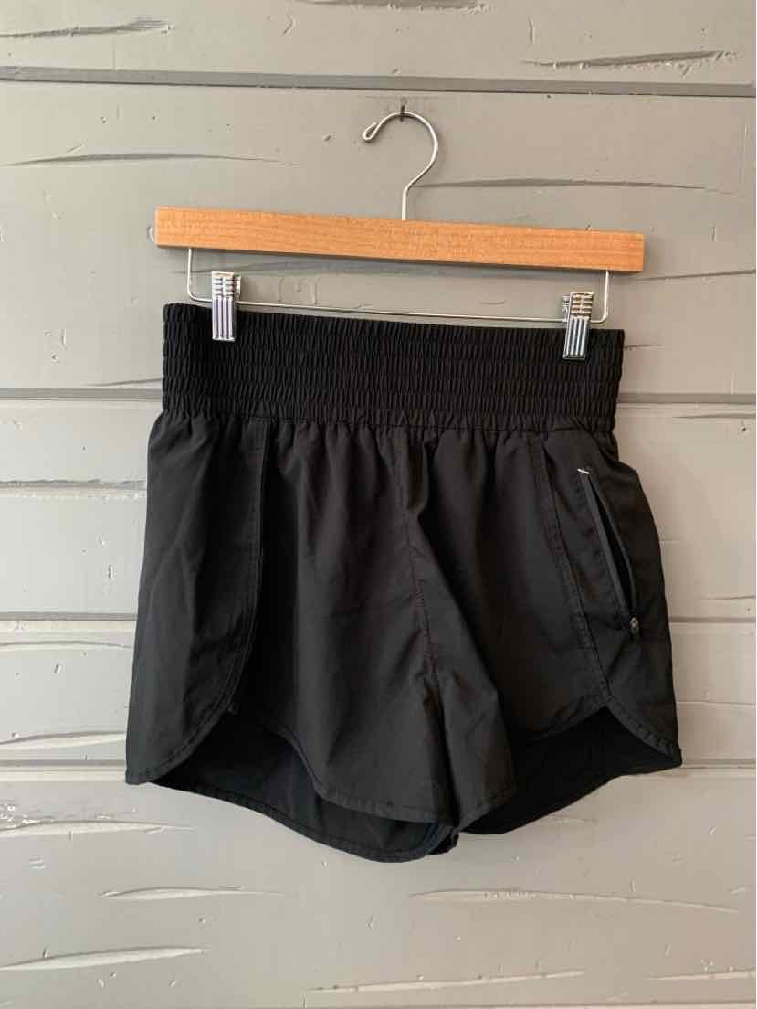 Black mid-length athletic shorts with elastic waistband and side pocket, made of lightweight fabric.