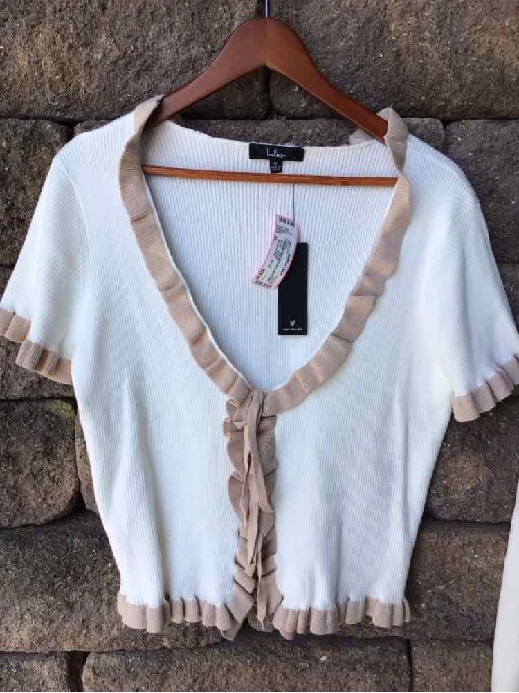 White short-sleeve cardigan with beige ruffled trim and button closure, size XL.