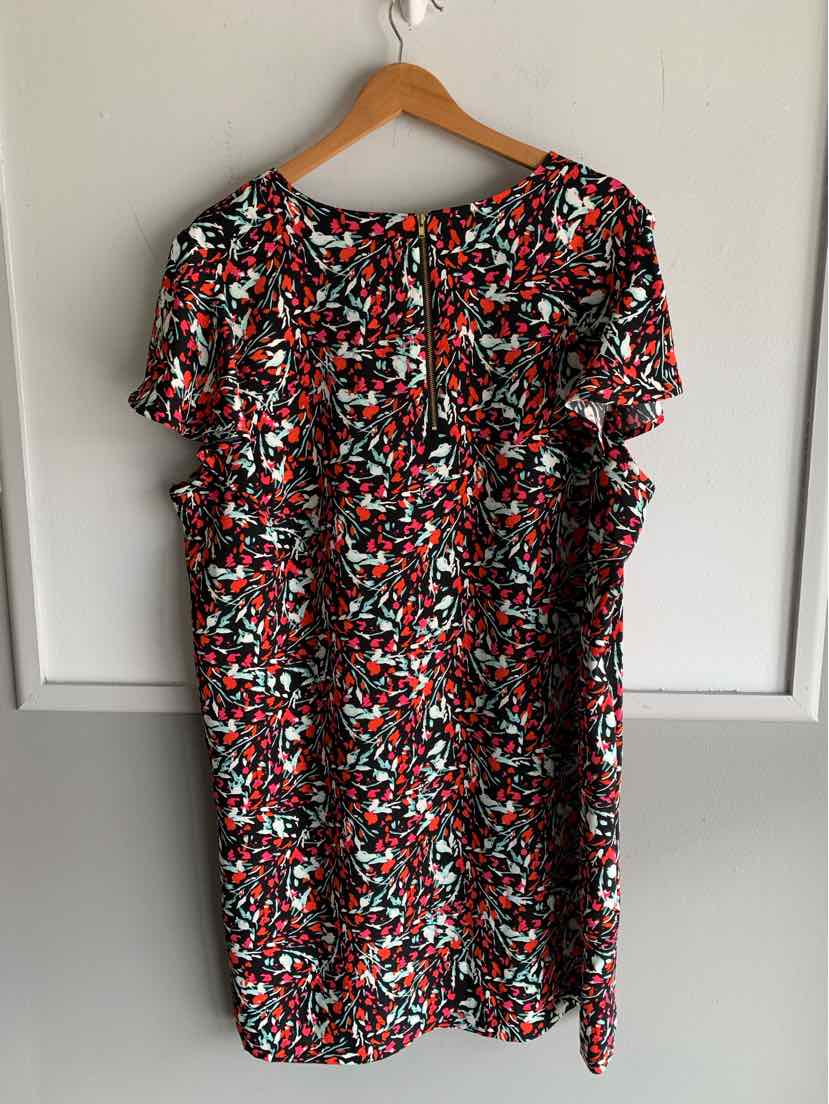 Plus-size short-sleeve dress with vibrant red, black, and white floral print and back zipper closure.