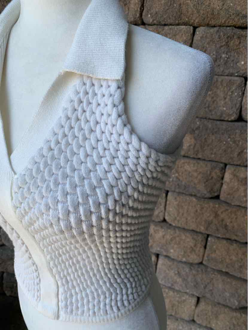 White sleeveless knit top with textured honeycomb pattern and wide collar.