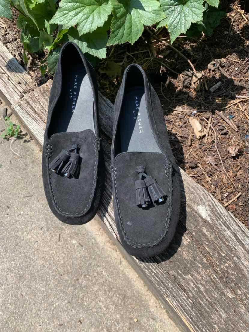 Black suede loafers with rounded toes, tassel accents, and low heels.