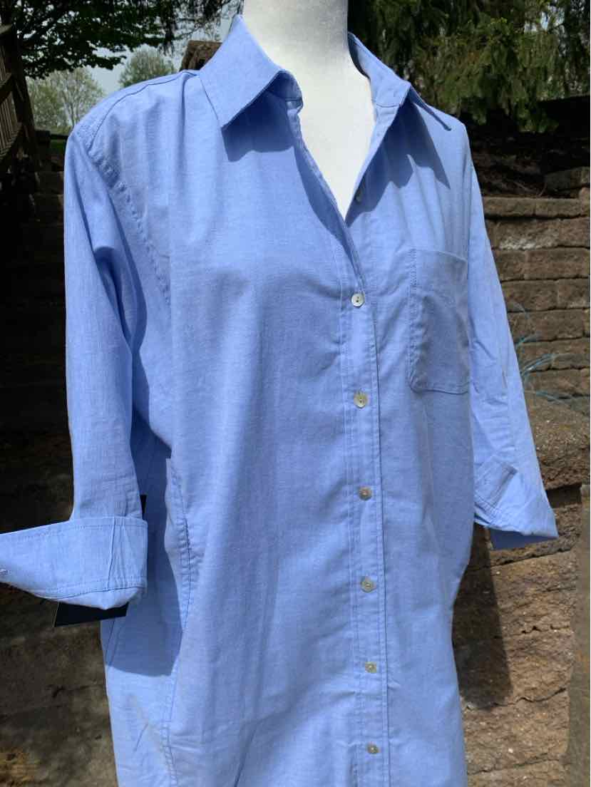 Light blue long-sleeve button-up shirt with collar and chest pocket, rolled cuffs.