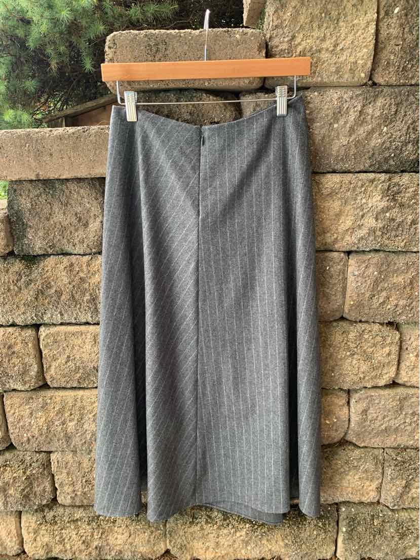 Gray pinstripe midi skirt with slight flare and smooth waistband hanging on wooden hanger.