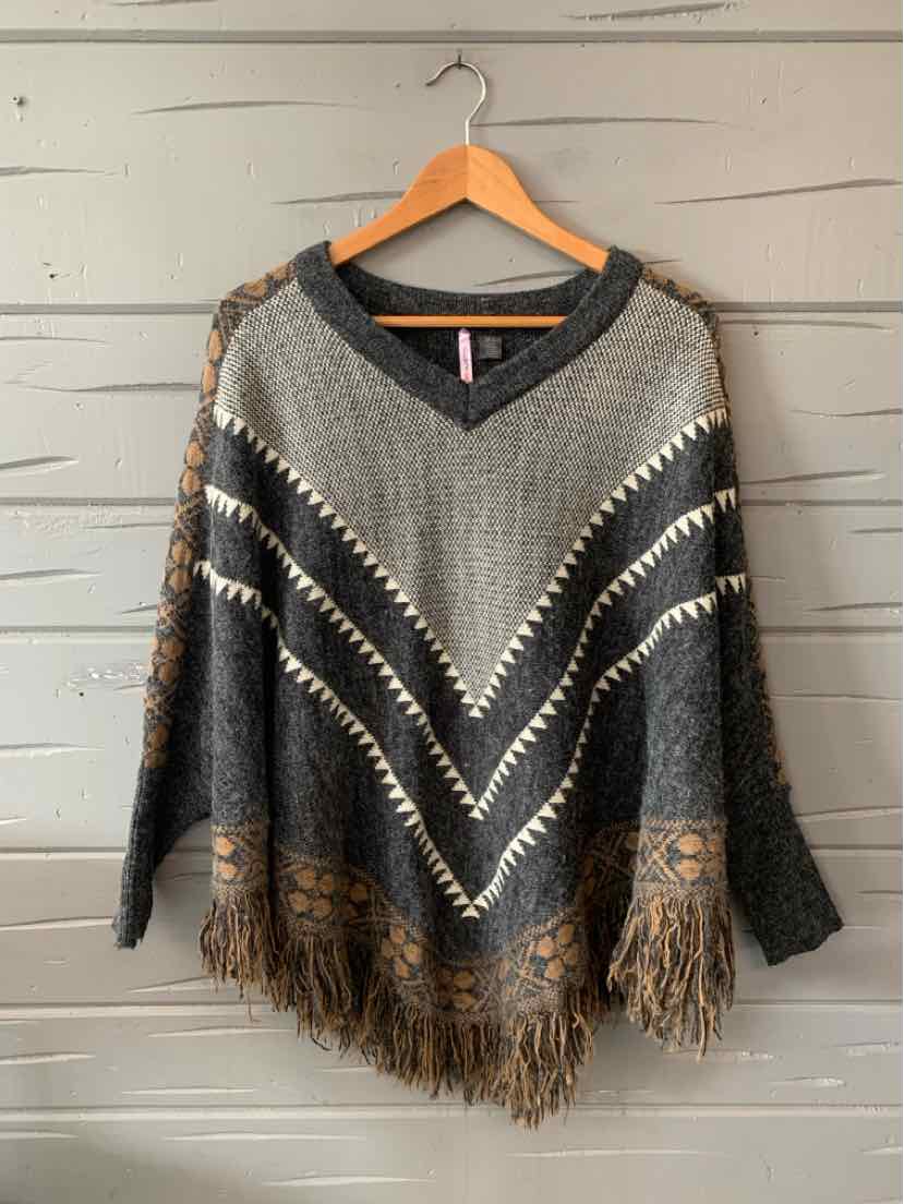 Gray knit poncho with chevron stripes in cream and brown, featuring fringe trim at hem.