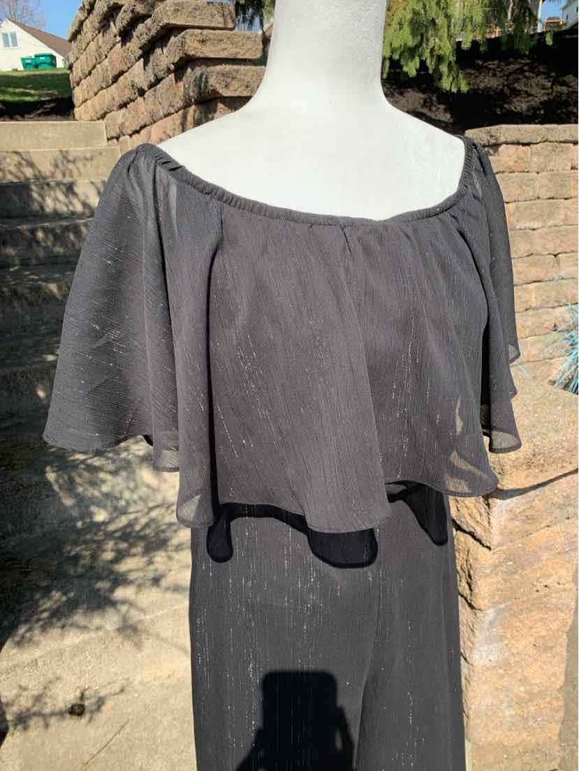 Black off-the-shoulder top with layered chiffon fabric and short flutter sleeves.