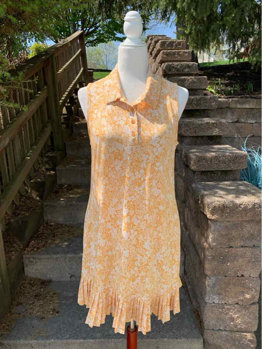 Sleeveless yellow floral dress with collar and pleated hem on white mannequin outdoors.