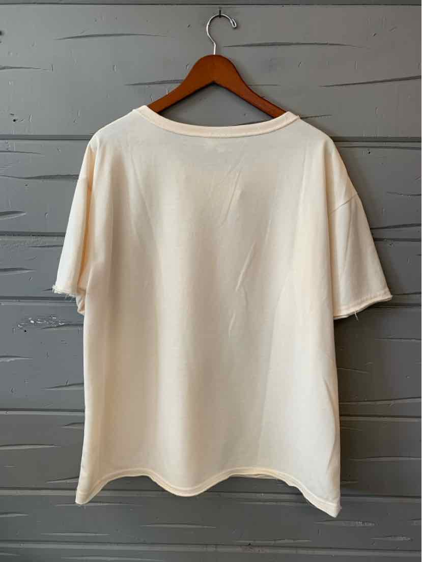 Plain white short-sleeve oversized cotton t-shirt with crew neck on wooden hanger.