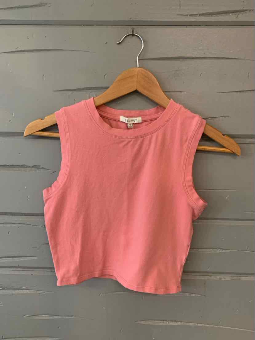 Sleeveless pink cropped tank top with round neckline on wooden hanger against gray wooden background.