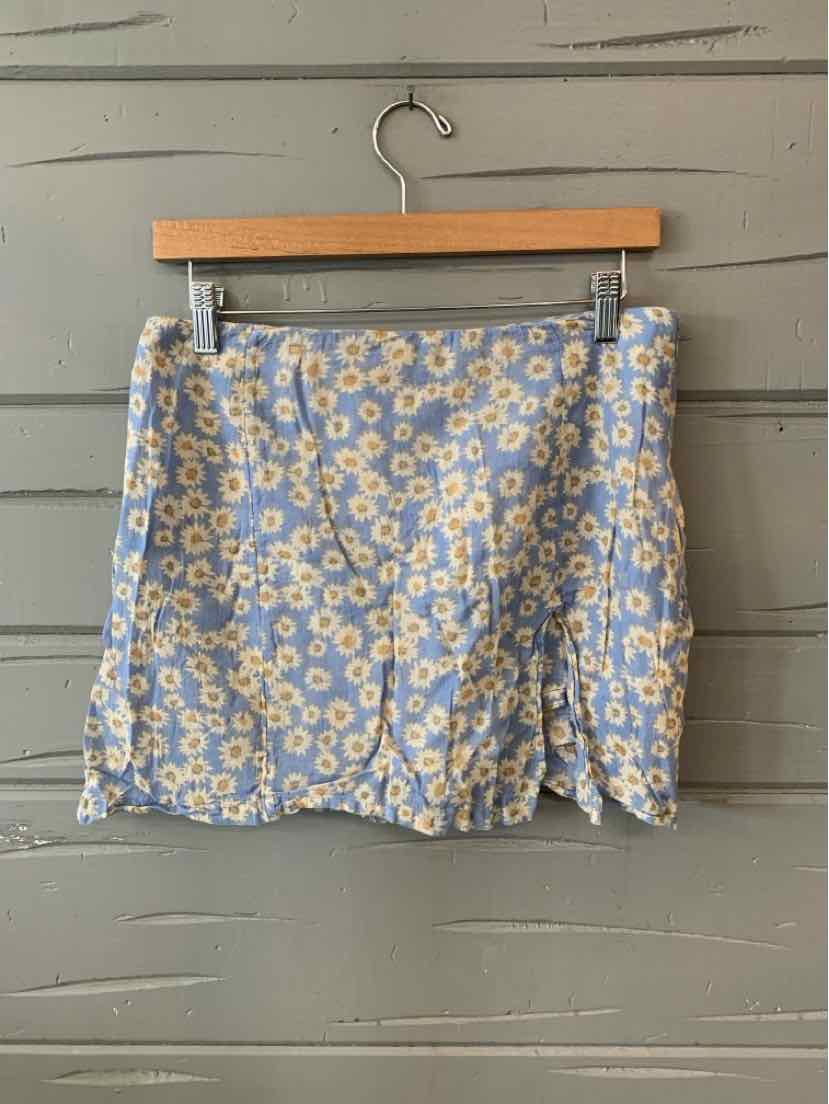 Blue mini skirt with white and yellow floral print, size 10, hanging on wooden hanger.