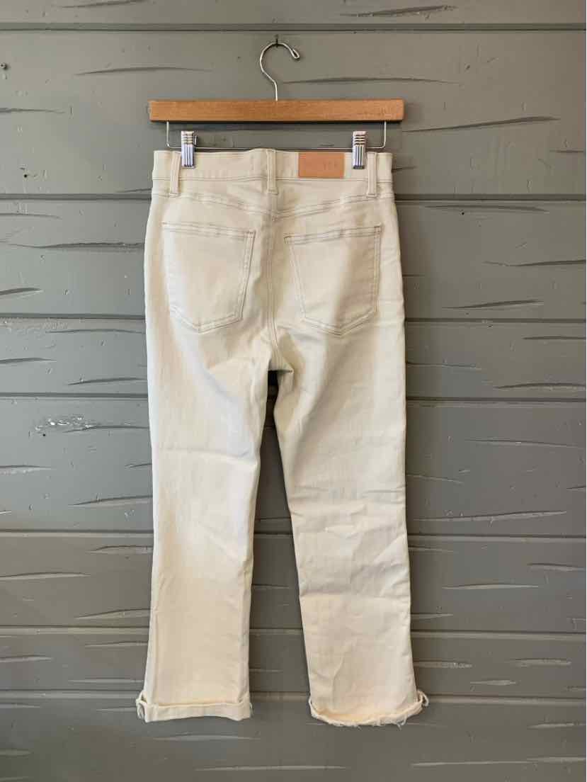 Beige cropped denim pants with straight legs, back pockets, and a frayed hem.