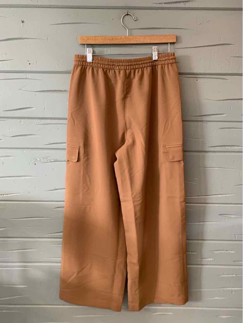 Tan wide-leg pants with elastic waistband and side cargo pockets, made from soft fabric.