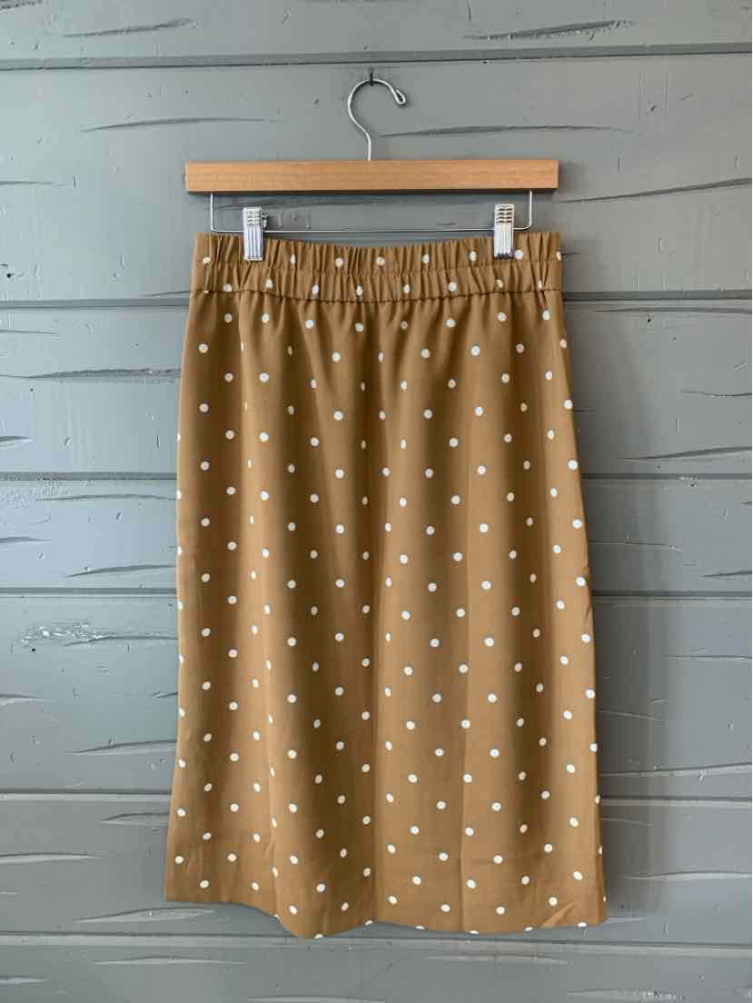 Tan knee-length skirt with white polka dots and an elastic waistband in size XS.