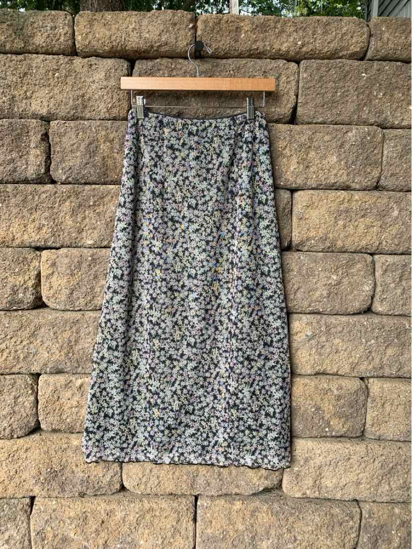 Midi skirt with small floral print in muted tones, lightweight fabric, elastic waistband.