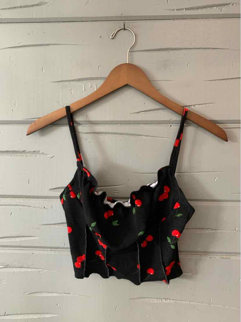 Black cropped camisole with red cherry print and adjustable thin straps.