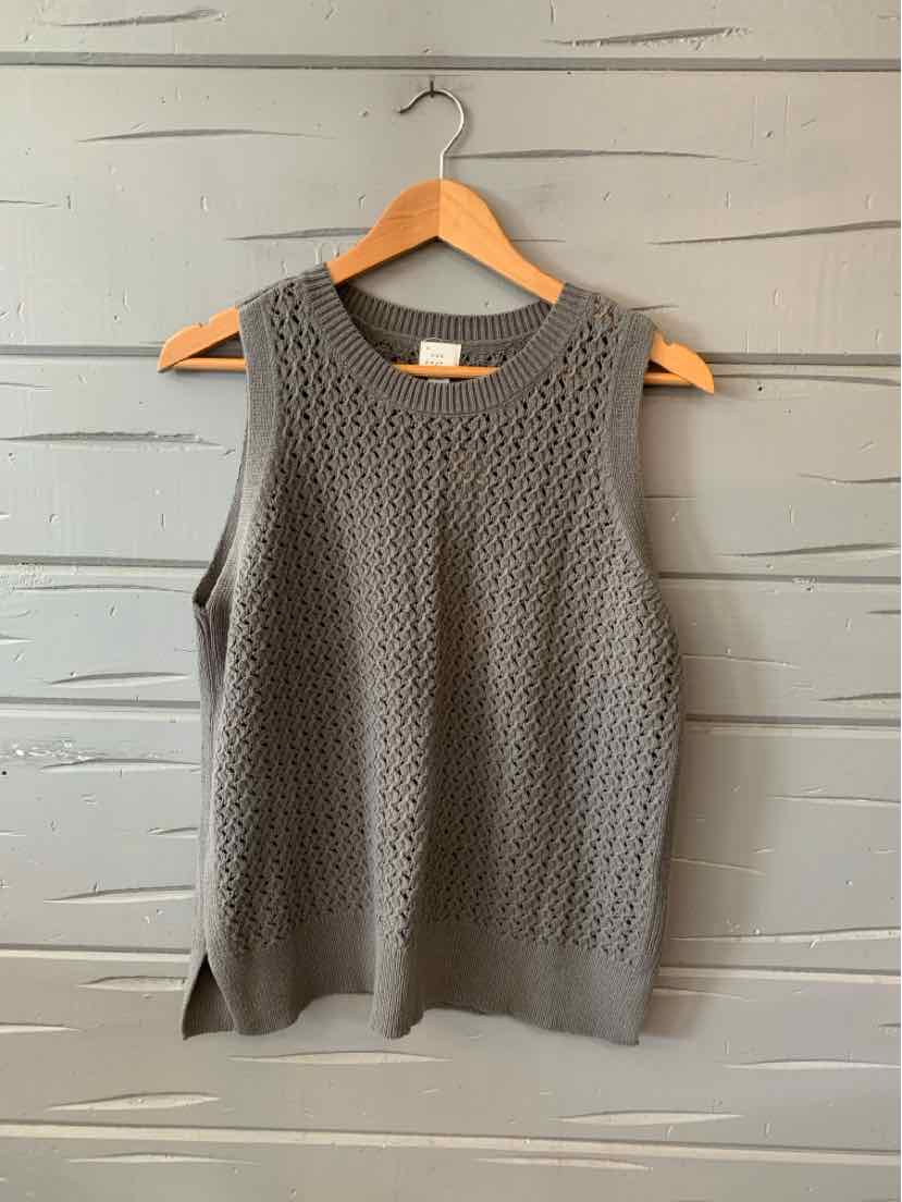 Gray sleeveless knit top with textured pattern and round neckline, hanging on wooden hanger.