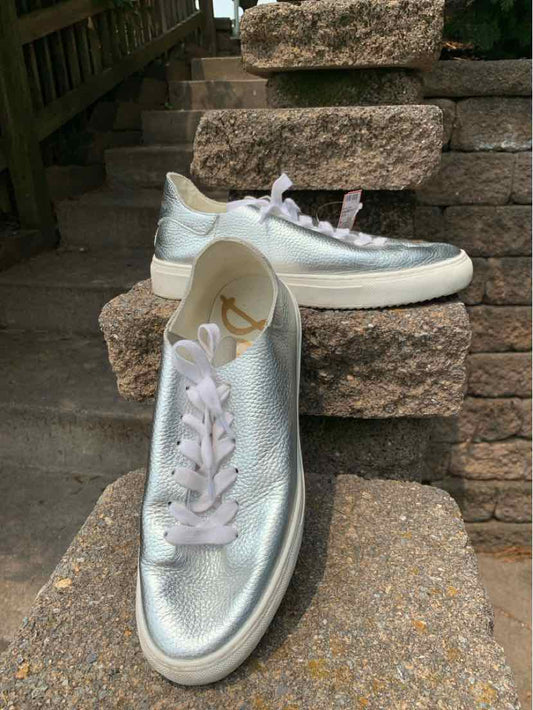 Silver metallic leather sneakers with white rubber soles and white laces, size 8.5.