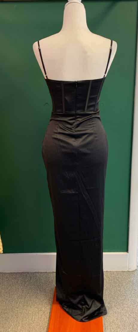 Black velvet sleeveless dress with thin straps and fitted silhouette on mannequin.