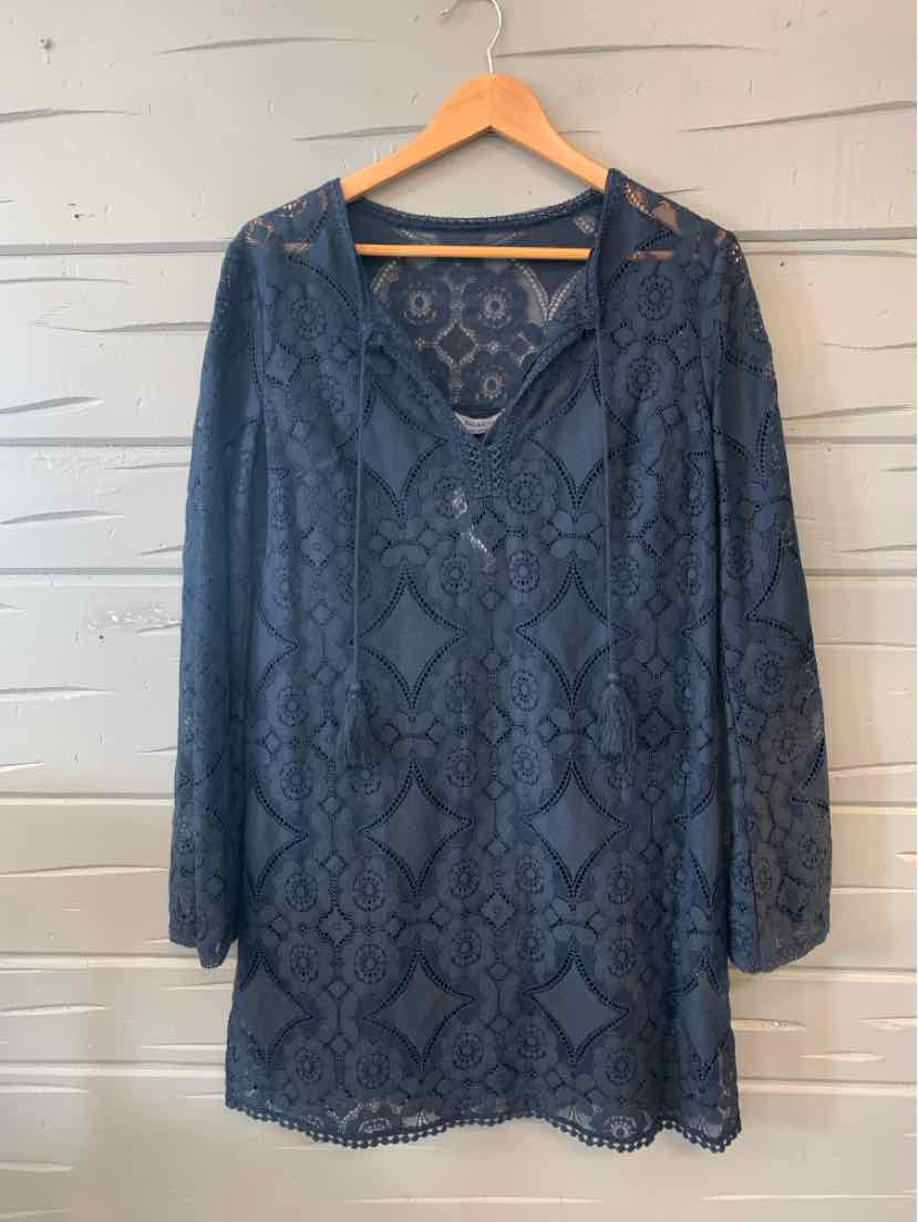 Dark navy blue lace long-sleeve blouse with scalloped hem and V-neck on wooden hanger.
