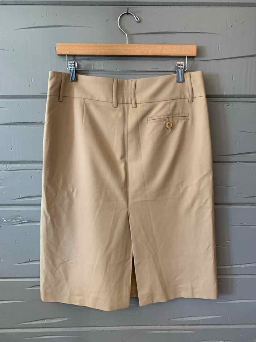Tan knee-length pencil skirt with belt loops and a back slit, made of smooth fabric.