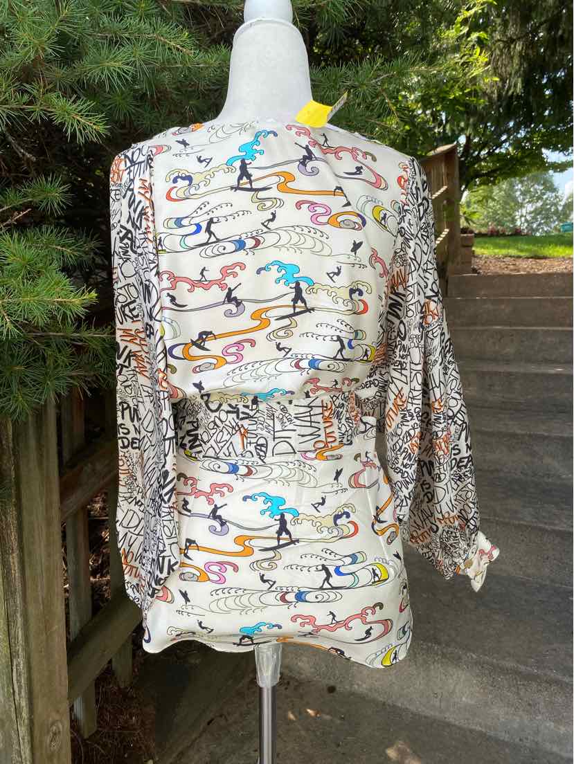 Long-sleeve dress with colorful abstract lizard patterns on white background, cinched waist, and loose sleeves.