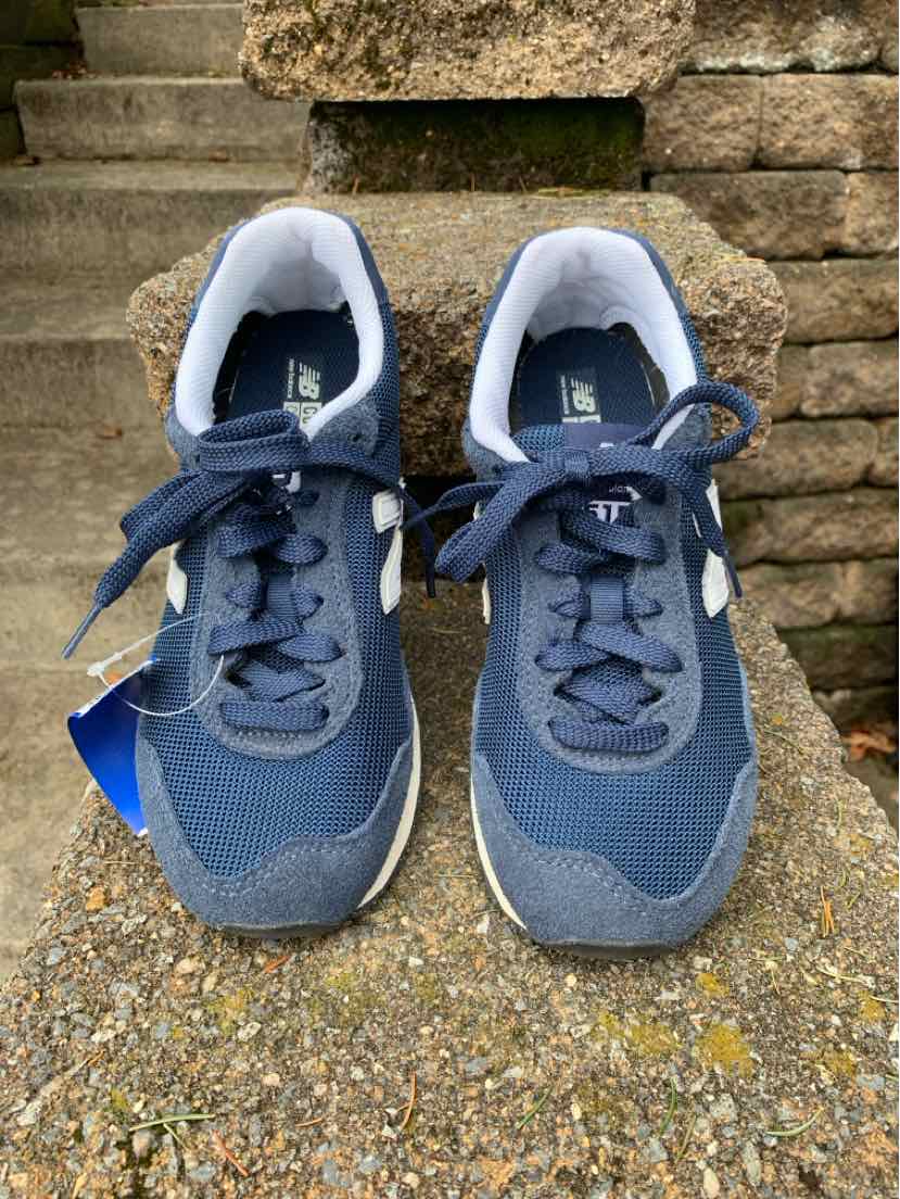 Navy blue and gray New Balance sneakers with white inner lining and laces, size 7, front view.