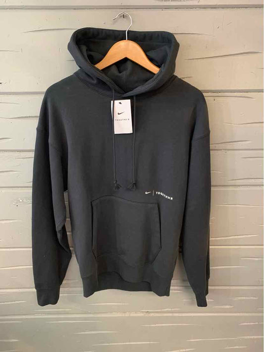 Black Nike hoodie in size XS with front kangaroo pocket and attached hood on wooden hanger.