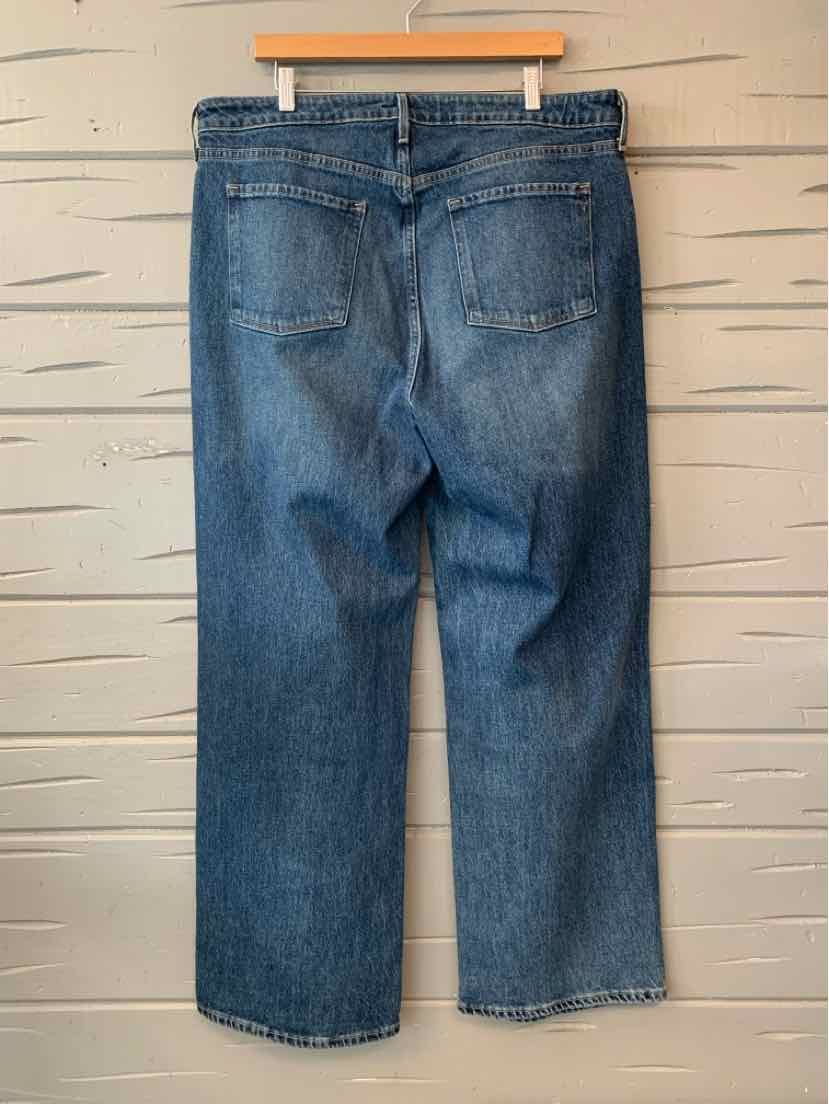 Blue denim jeans size 16 with back pockets and straight leg hanging on wooden hanger.