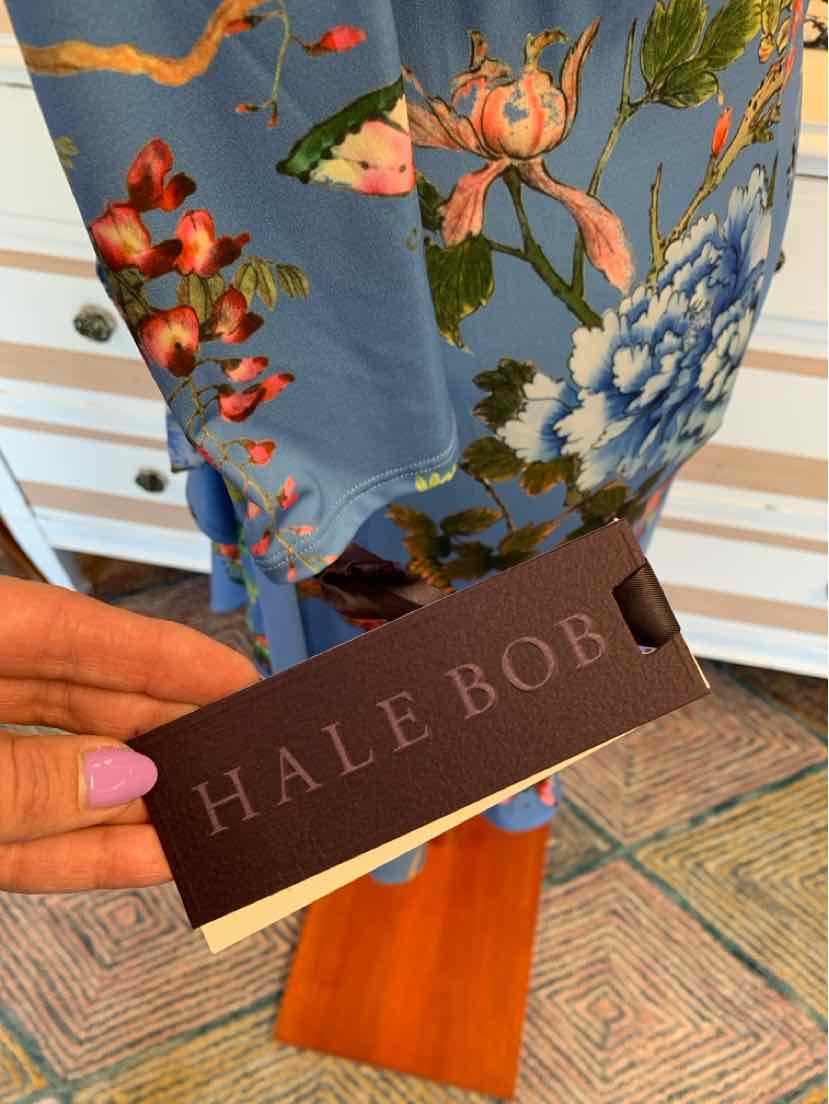 Blue floral dress fabric with large pink and white flowers and green leaves, held with a brown Hale Bob tag.