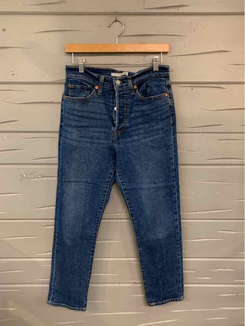 High-waisted dark blue denim jeans with button fly and straight leg, size 10, hanging on wooden hanger.