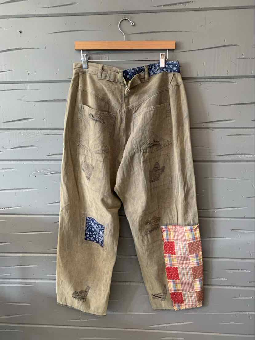 Beige loose-fit pants with patchwork details in blue and red plaid, featuring a slightly tapered leg and an elastic.