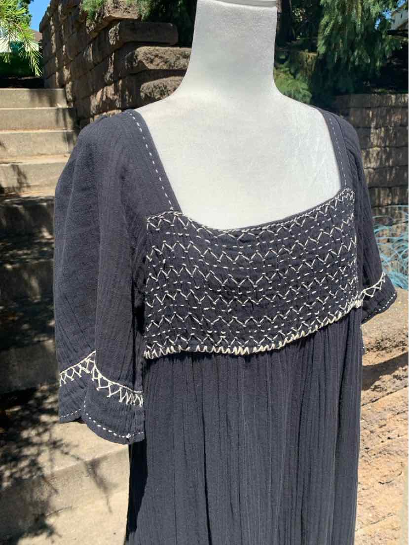 Black bohemian dress with cropped overlay, zigzag embroidered trim on sleeves and neckline, lightweight fabric.