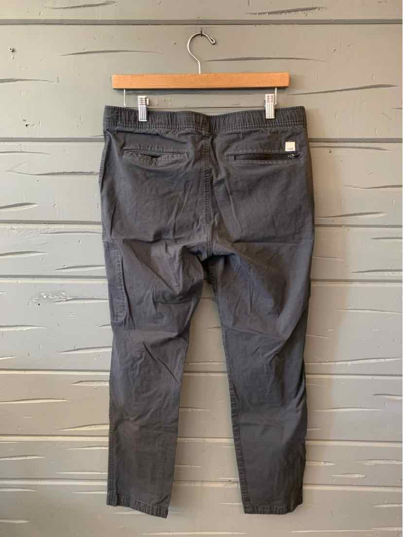 Charcoal gray Vuori pants with a slim tapered fit, belt loops, front pockets, and a zip fly.