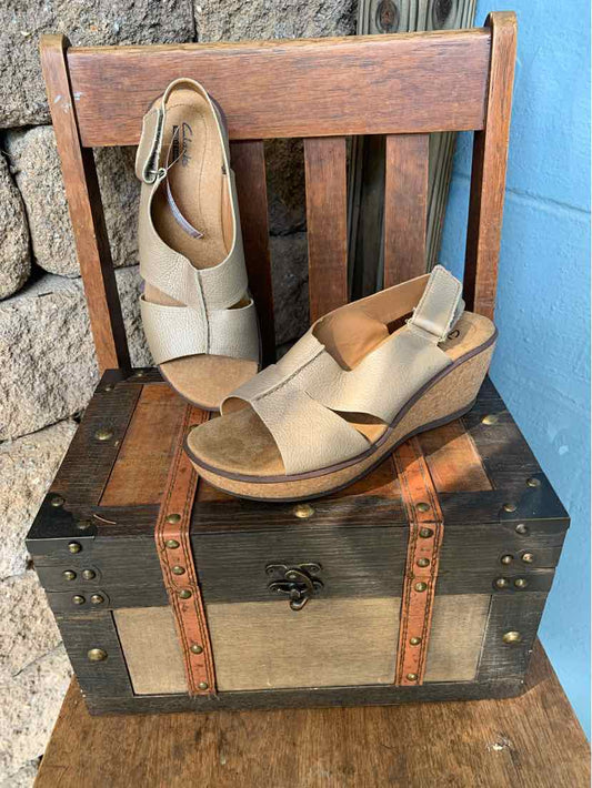 Beige leather wedge sandals with crisscross straps and adjustable ankle buckle, size 7.5.