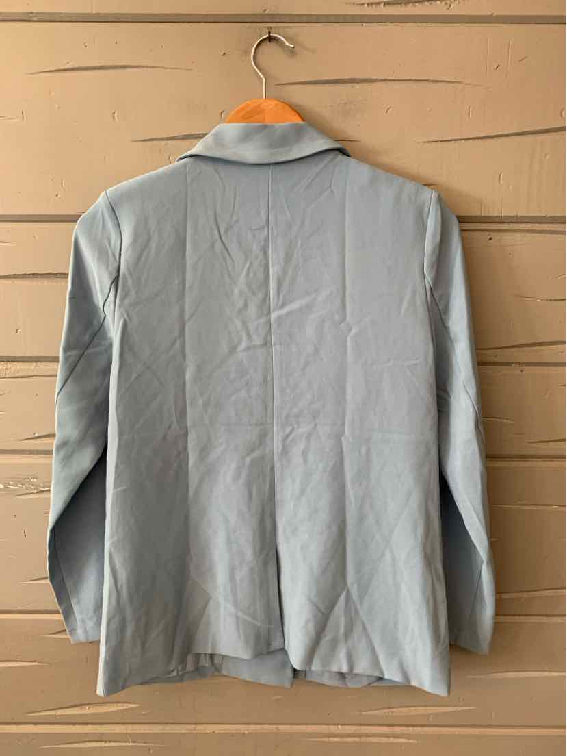 Light blue long-sleeve blazer with collar and smooth fabric hanging on wooden hanger.
