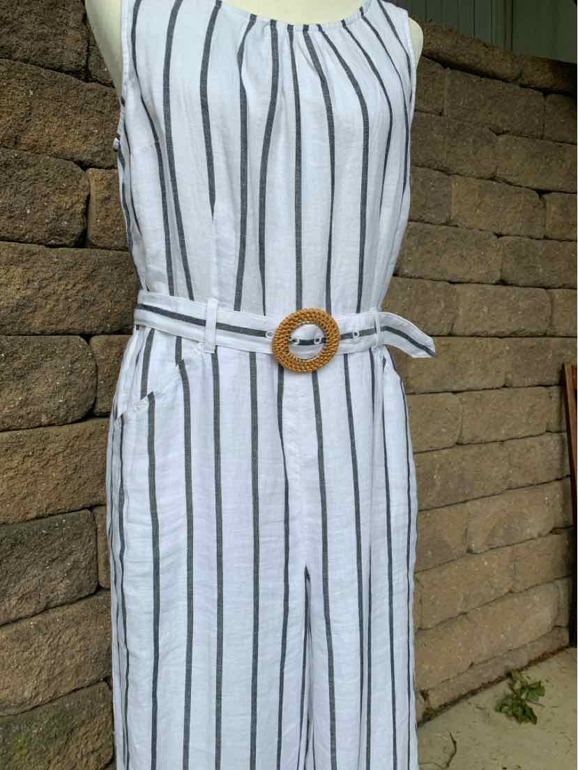 White sleeveless dress with black vertical stripes and a wooden buckle belt.