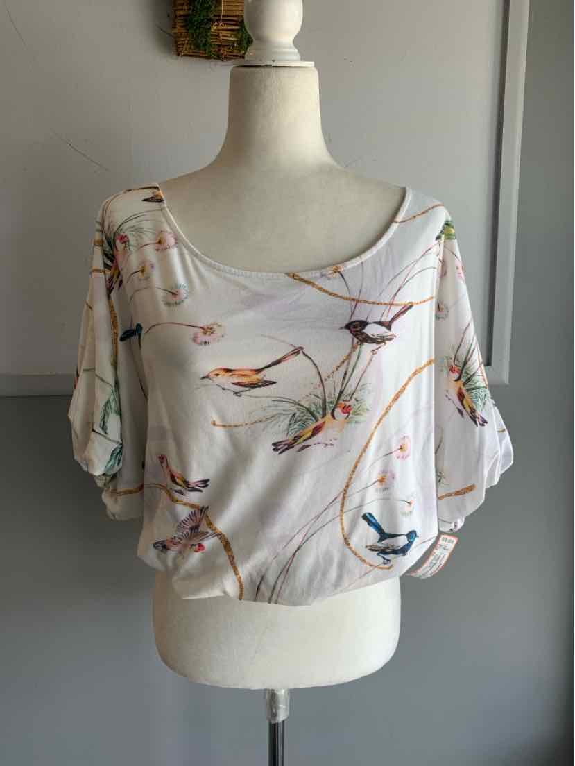 White short-sleeve blouse with wide neckline and colorful bird print designs.