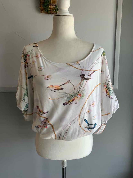 White short-sleeve blouse with wide neckline and colorful bird print designs.