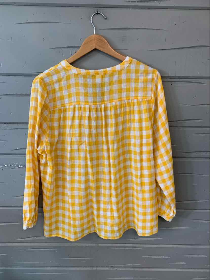 Yellow and white gingham long-sleeve blouse with round neckline on wooden hanger.