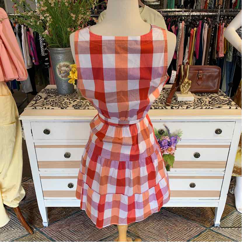 Orange and white plaid sleeveless dress with fitted waist and flared skirt on mannequin.