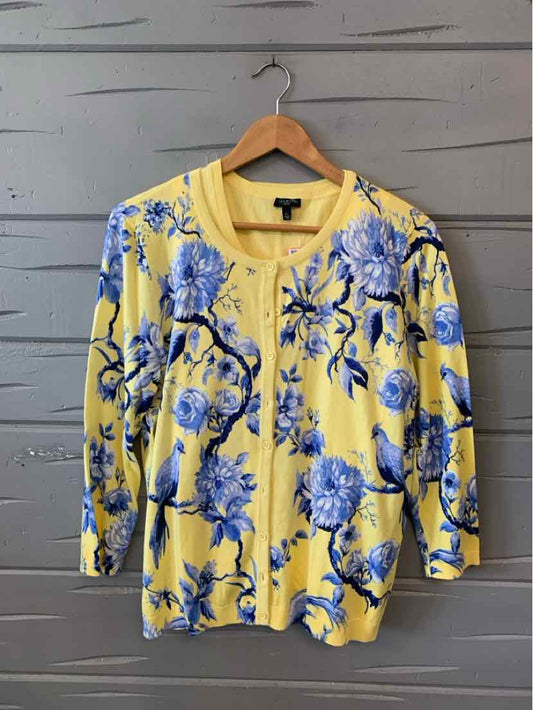 Yellow cardigan with blue floral print, round neckline, button-front, and long sleeves.