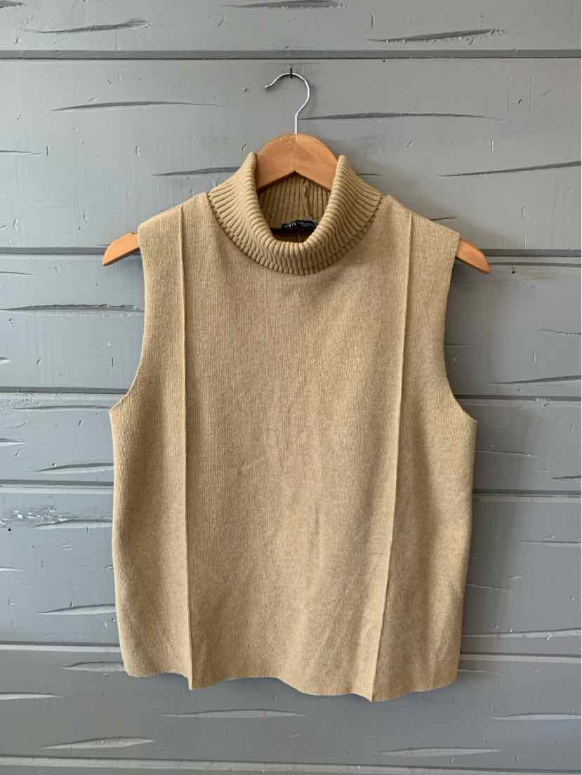 Tan sleeveless knit turtleneck sweater in medium size hanging on wooden hanger.