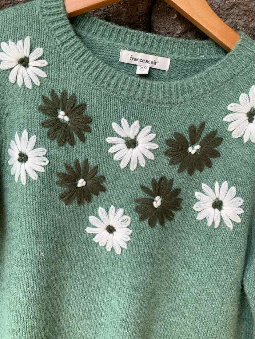 Green knit sweater with white and dark green embroidered daisies around the neckline.
