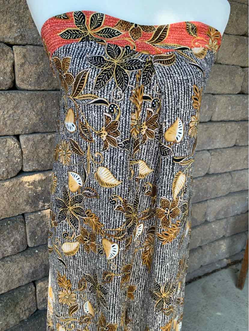 Strapless floral dress with black, white, and brown patterns, featuring an orange floral band at the top.