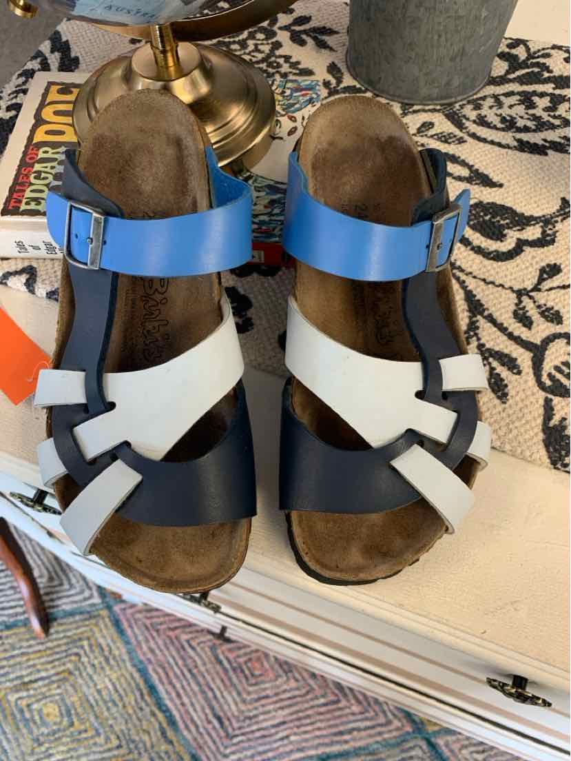 Women’s Birkenstock multi-strap sandal in blue, black, and white leather with adjustable buckle on size 37 footbed.