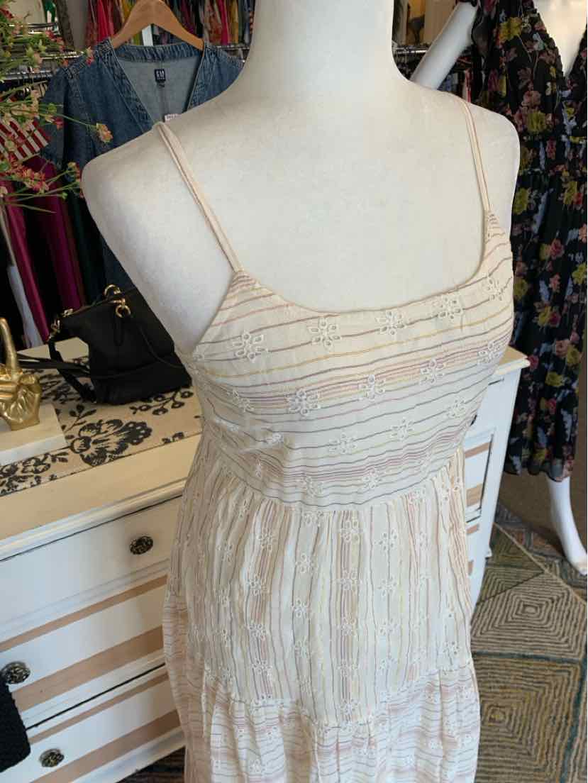 Beige sleeveless dress with thin spaghetti straps, eyelet fabric texture, and a fitted bodice with subtle vertical stripes.
